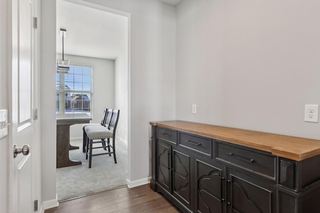 interior space with baseboards and dark wood-type flooring