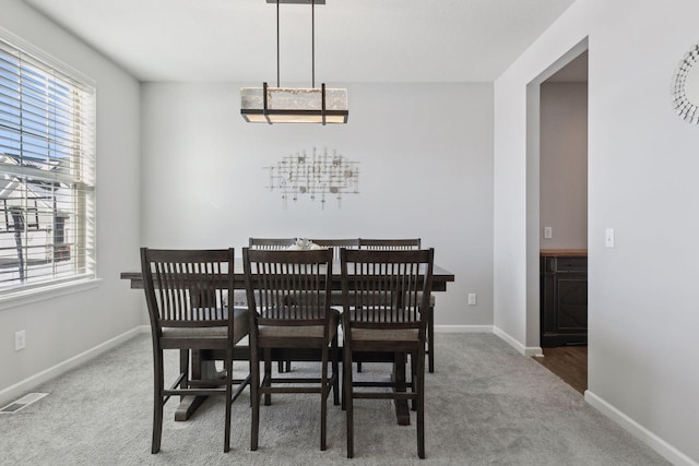 dining room featuring carpet floors, baseboards, and visible vents