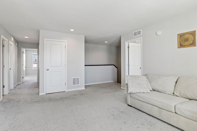 living room with baseboards, visible vents, and light colored carpet