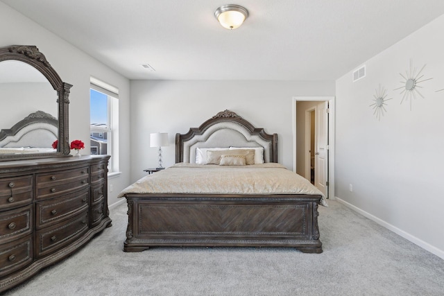 bedroom with visible vents, light carpet, and baseboards