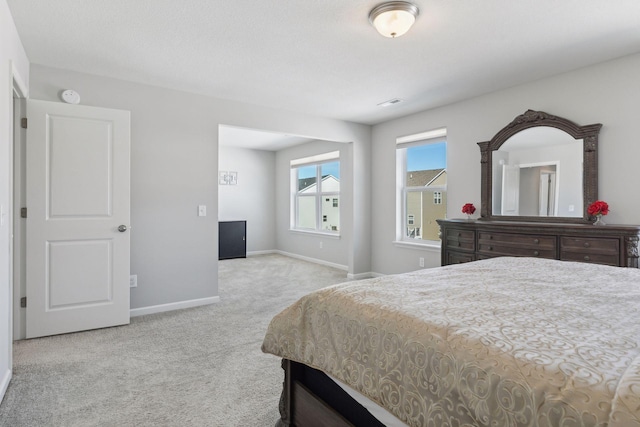 bedroom featuring light carpet and baseboards