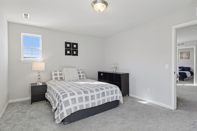 bedroom featuring light carpet, visible vents, and baseboards