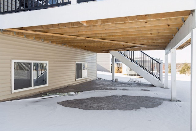 snow covered patio featuring stairs