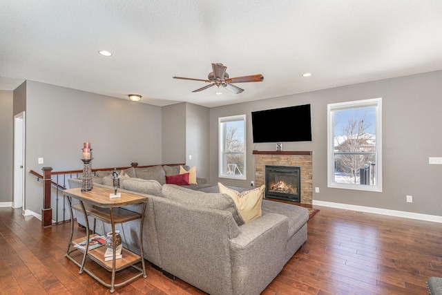 living room with a fireplace, ceiling fan, and dark hardwood / wood-style flooring