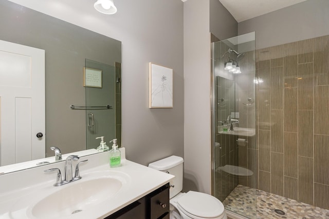 bathroom with an enclosed shower, vanity, and toilet