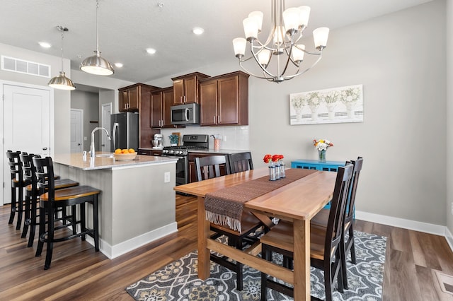 dining room with sink, dark hardwood / wood-style floors, and a textured ceiling