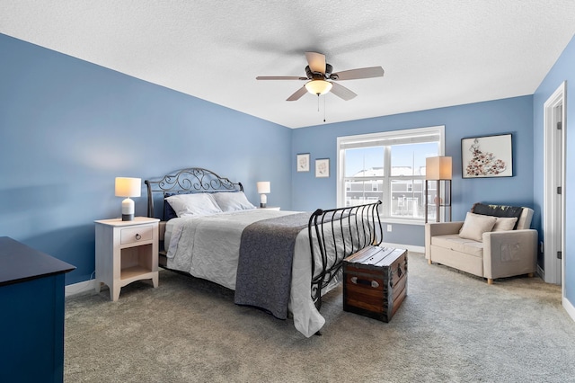 bedroom featuring a textured ceiling, carpet flooring, and ceiling fan