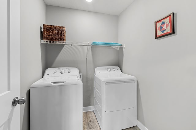 laundry room featuring washing machine and clothes dryer and light wood-type flooring