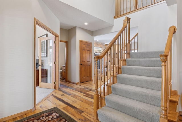 stairway with recessed lighting, baseboards, and hardwood / wood-style floors