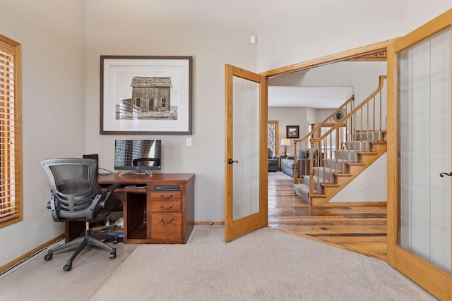 carpeted office with french doors and baseboards