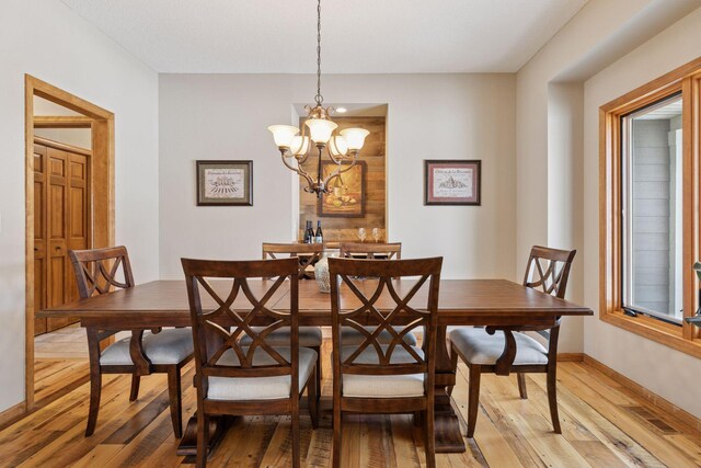 dining room featuring visible vents, a notable chandelier, baseboards, and light wood-type flooring