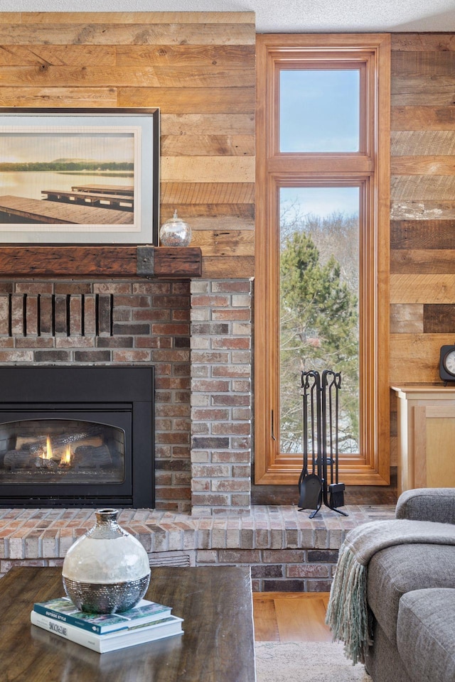 details with a brick fireplace, wooden walls, and wood finished floors