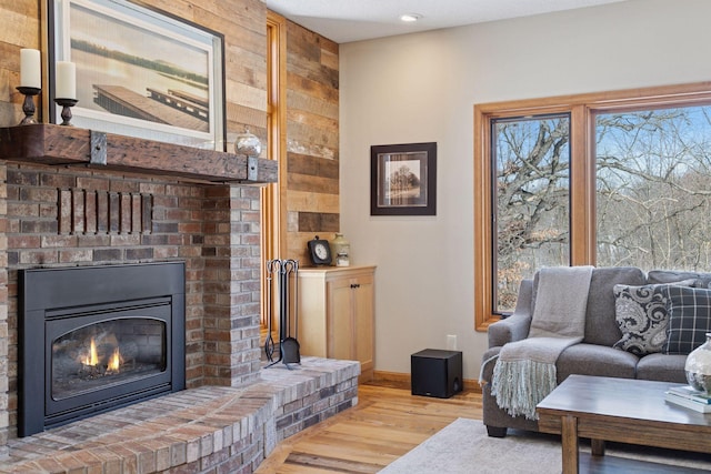 living area featuring a fireplace, wood finished floors, and baseboards