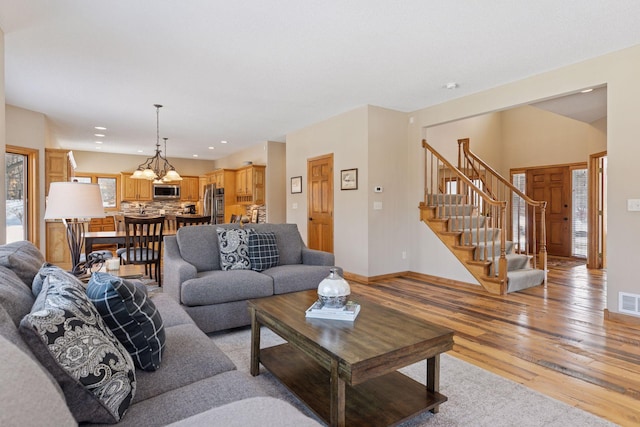 living room featuring visible vents, recessed lighting, light wood-style floors, baseboards, and stairs