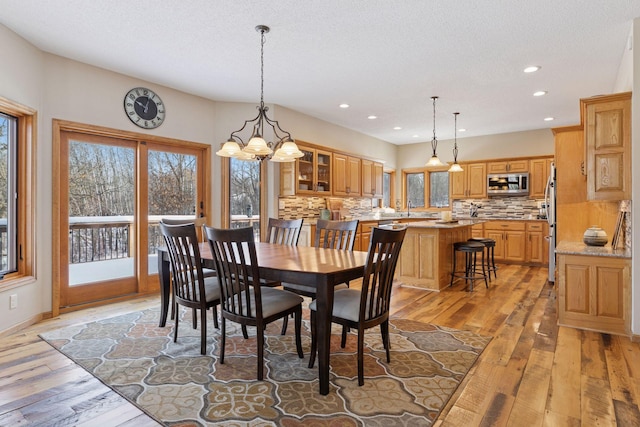 dining room with recessed lighting, light wood-type flooring, and a textured ceiling