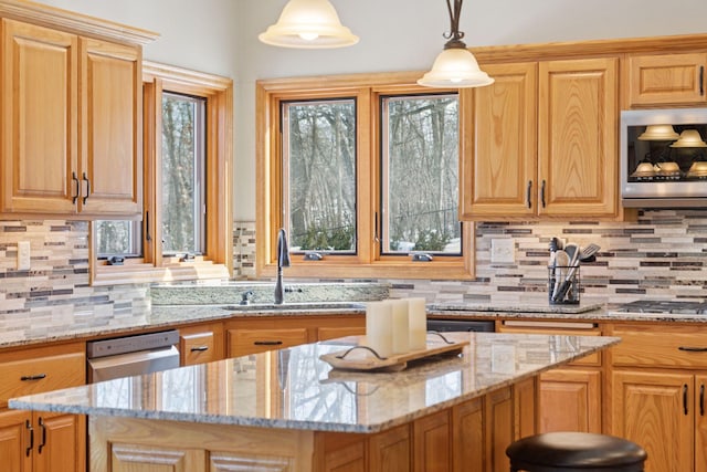 kitchen with light stone countertops, appliances with stainless steel finishes, and a sink