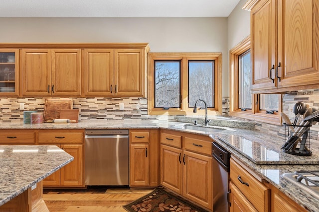 kitchen featuring a sink, tasteful backsplash, appliances with stainless steel finishes, and light wood-style flooring