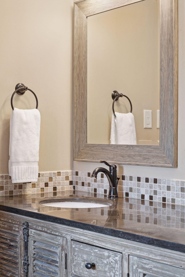 bathroom with a sink and tasteful backsplash