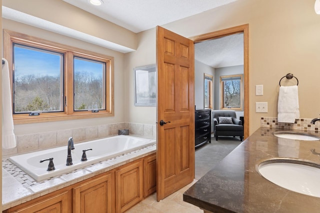 bathroom with plenty of natural light, a textured ceiling, and a sink