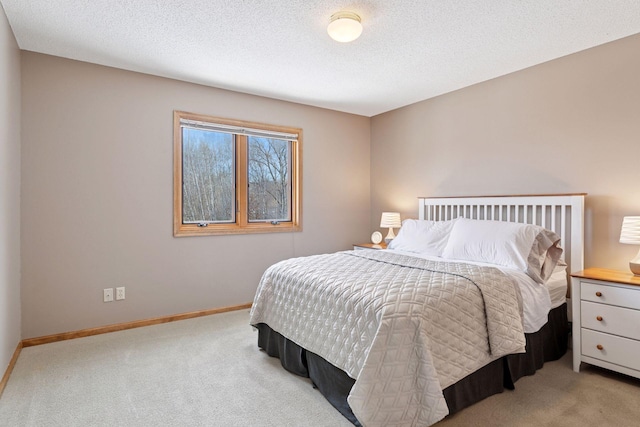 carpeted bedroom with baseboards and a textured ceiling