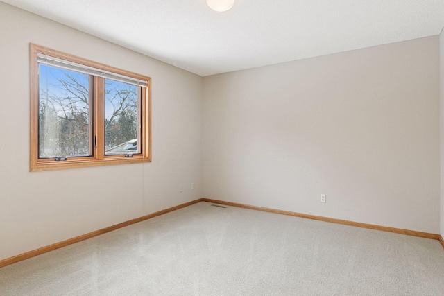 unfurnished room with visible vents, baseboards, and carpet flooring