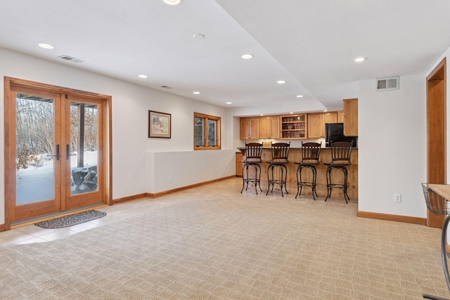 kitchen with baseboards, visible vents, a breakfast bar, recessed lighting, and black fridge