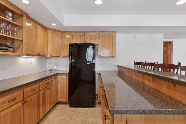 kitchen with recessed lighting, open shelves, light tile patterned floors, and freestanding refrigerator