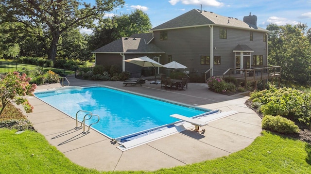 view of pool with a wooden deck, a patio area, a fenced in pool, and fence