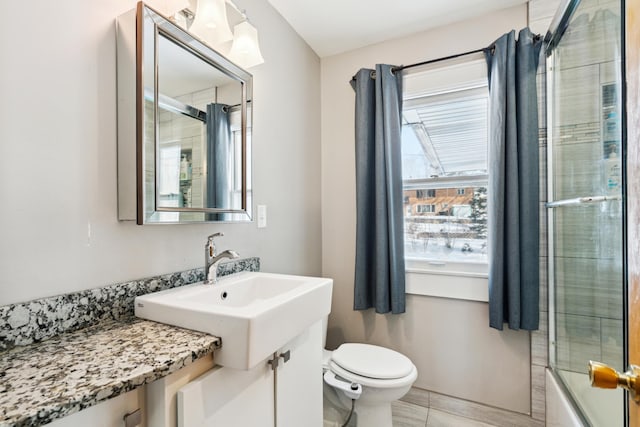 full bathroom featuring plenty of natural light, bath / shower combo with glass door, vanity, and toilet