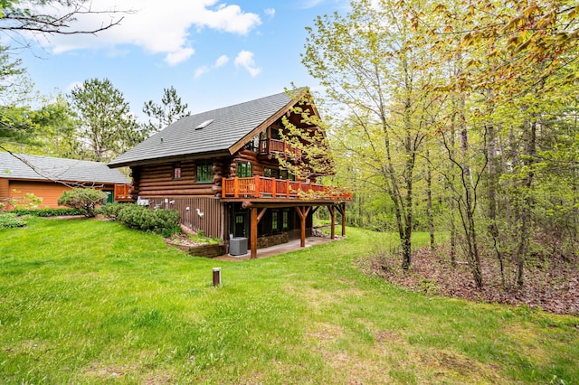 rear view of property featuring a yard and a wooden deck