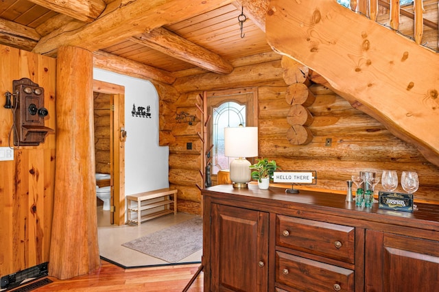 interior space featuring beamed ceiling, light hardwood / wood-style flooring, and wooden ceiling