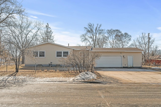 view of front of house with concrete driveway, an attached garage, and fence