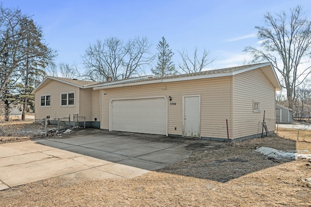 exterior space featuring driveway, a garage, and fence