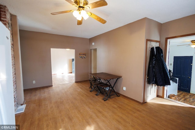 foyer with a ceiling fan, baseboards, and light wood finished floors