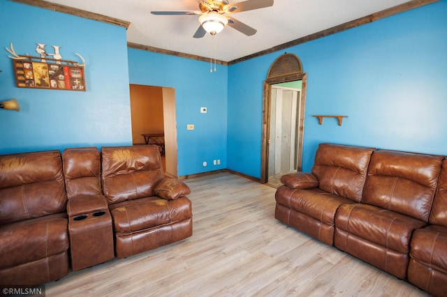 living area featuring light wood-style flooring, crown molding, baseboards, and a ceiling fan