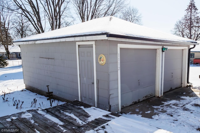 snow covered garage with a detached garage