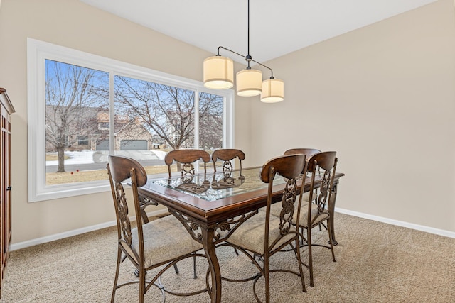 dining space featuring light carpet and baseboards