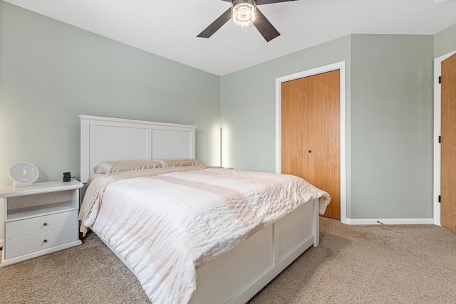 bedroom featuring light carpet, a closet, a ceiling fan, and baseboards