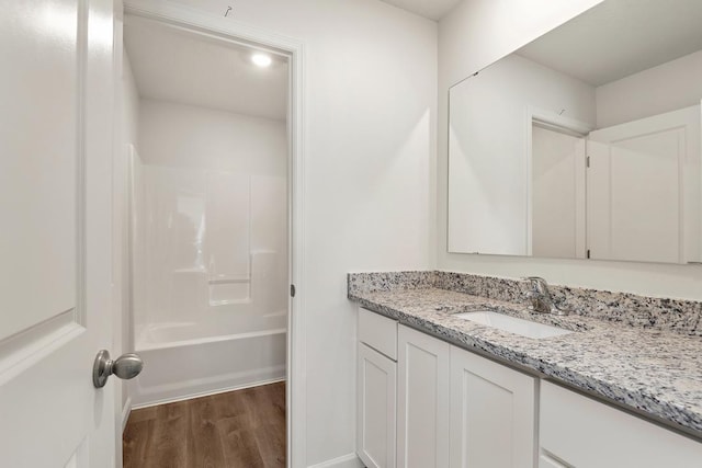 full bathroom featuring bathtub / shower combination, wood finished floors, and vanity