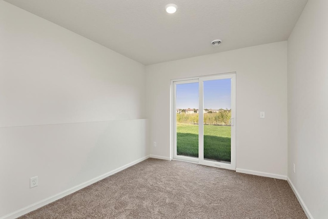 carpeted spare room featuring baseboards