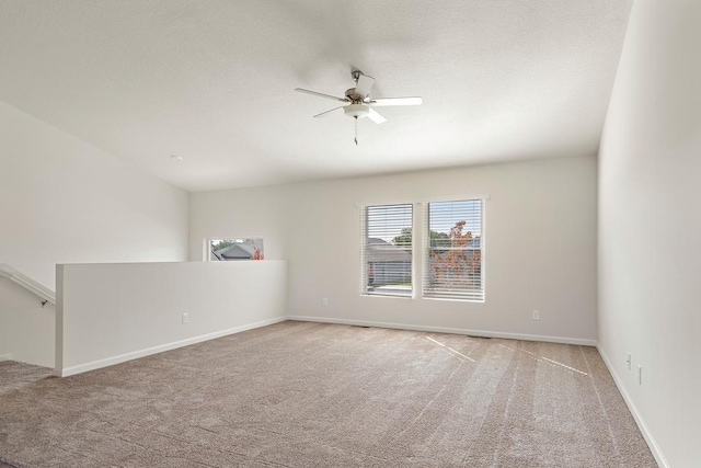 spare room with a ceiling fan, baseboards, carpet floors, and a textured ceiling