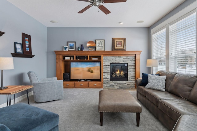 carpeted living room with ceiling fan and a fireplace