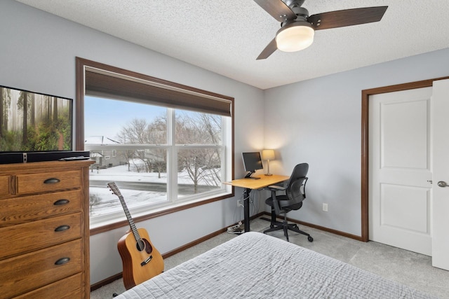 office space with ceiling fan, light carpet, and a textured ceiling