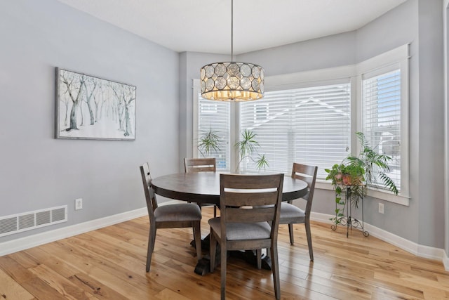 dining area featuring plenty of natural light, an inviting chandelier, and light hardwood / wood-style floors