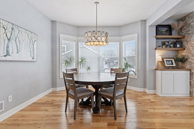 dining room with a notable chandelier and light hardwood / wood-style floors