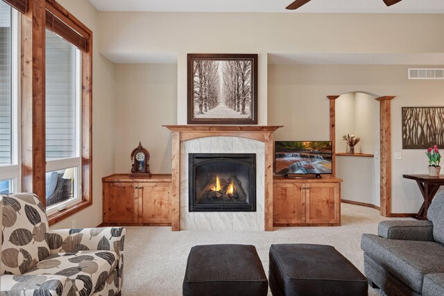 living area with visible vents, baseboards, carpet, and a fireplace