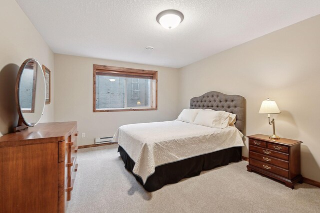 bedroom with a baseboard radiator, light carpet, and baseboards