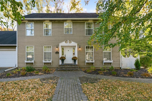 colonial-style house with entry steps and a garage