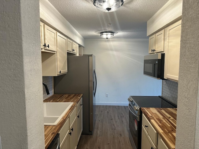 kitchen with sink, range with electric cooktop, tasteful backsplash, and wood counters