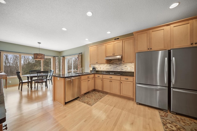 kitchen with kitchen peninsula, stainless steel appliances, light hardwood / wood-style floors, light brown cabinets, and pendant lighting